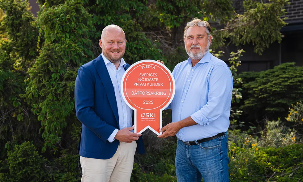 Svedeas vd Jonas Roberts och Göran Södergren, affärsansvarig båt och vattenskoter, står utomhus i naturen, hållandes en medalj som visar att Svedea har Sveriges nöjdaste privatkunder inom båtförsäkring.)