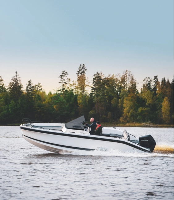 Motorbåt av tillverkaren Ryds färdas snabbt på en sjö omgiven av skog i bakgrunden.