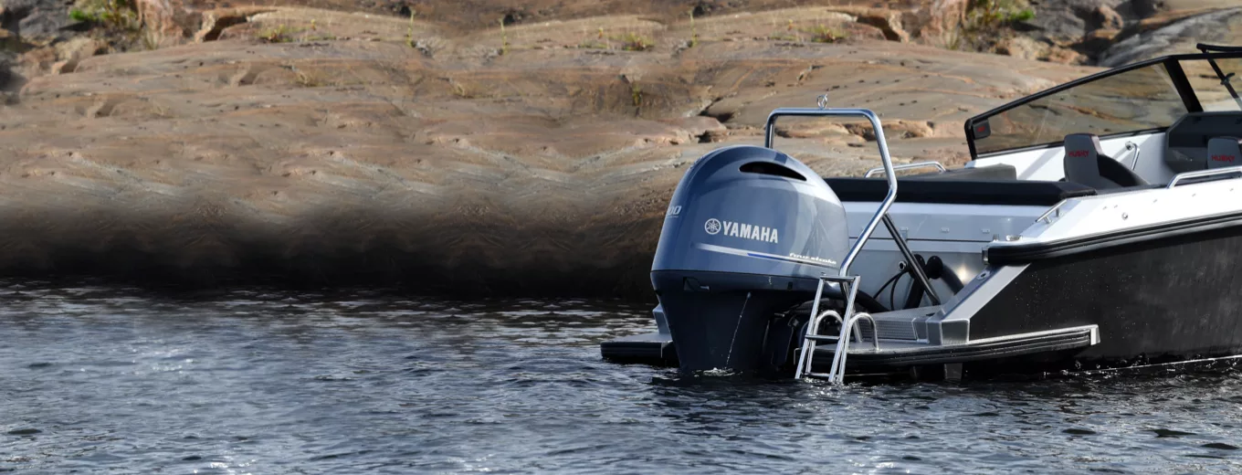 Båt med Yamahamotor som lagt till vid klippa.