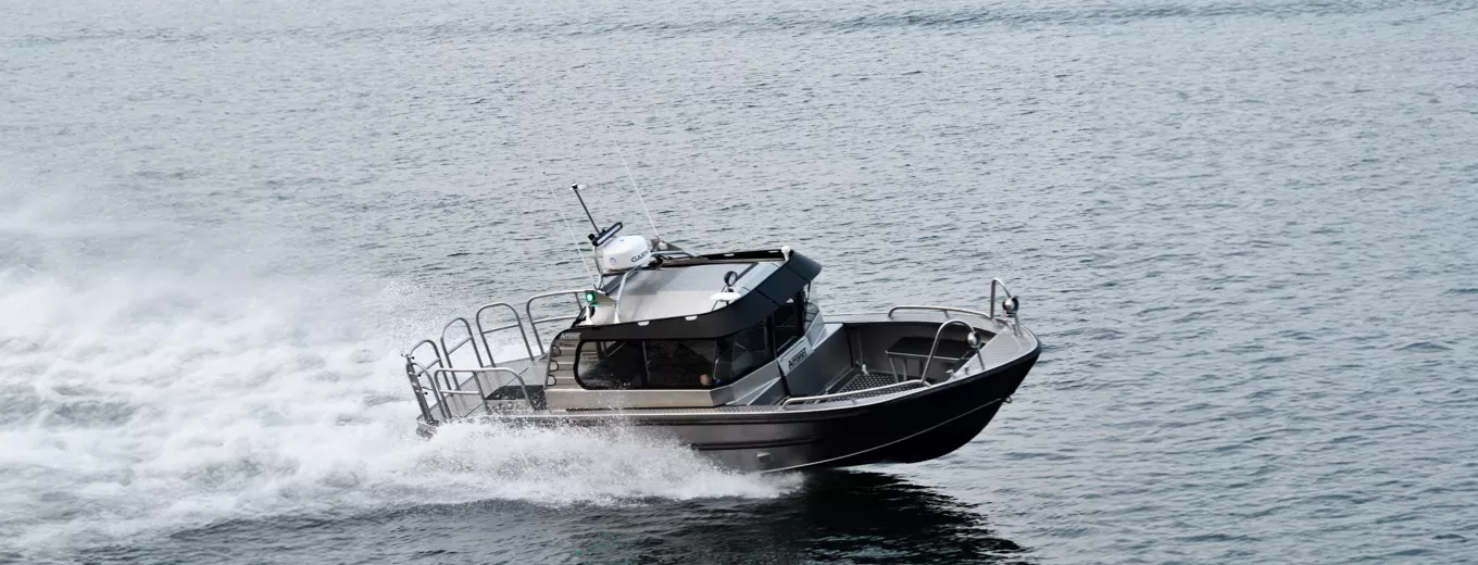 Aluminiumbåt av märket Arronet med kabin kör snabbt över ett öppet hav.
